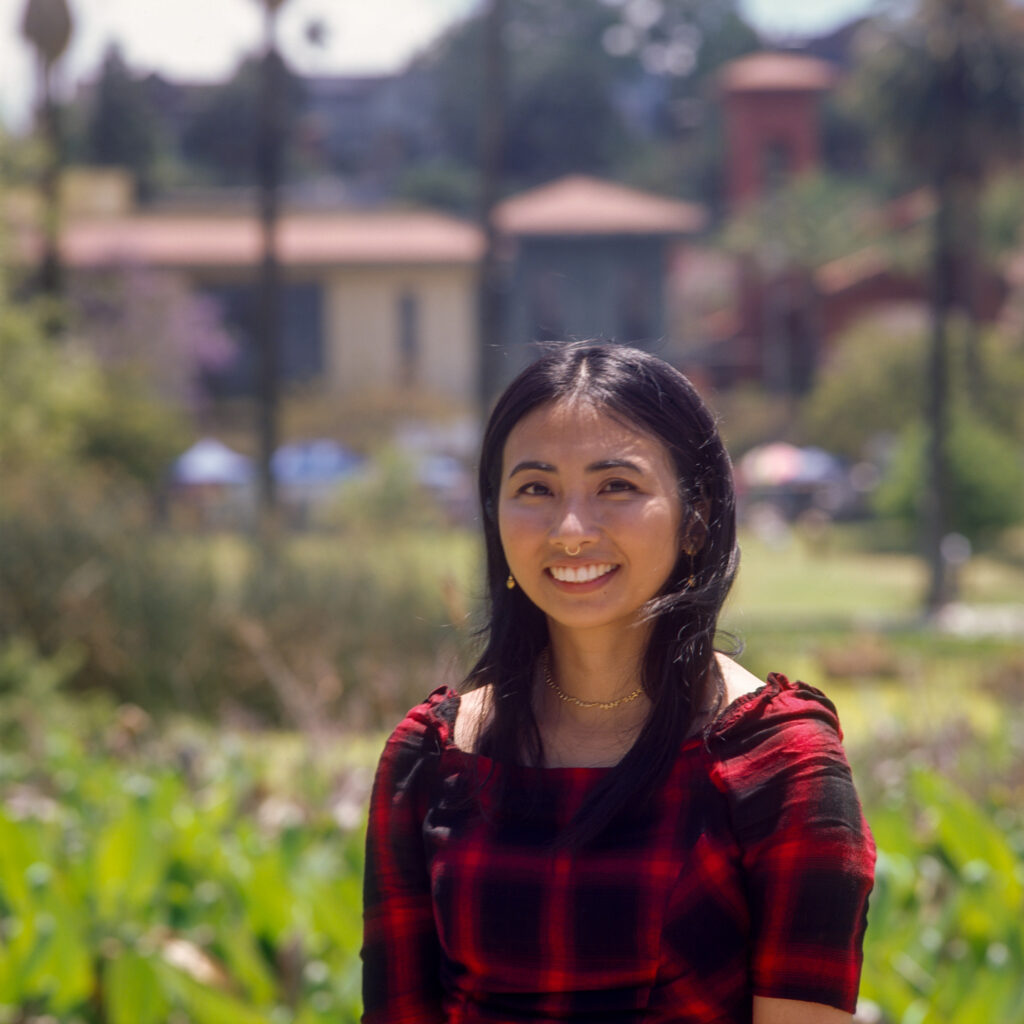 MT Vallarta, a non-binary and femme Filipinx poet, smiles in Echo Park, Los Angeles.
