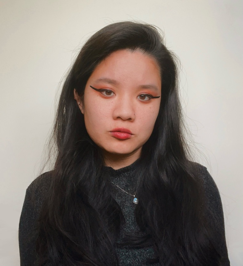 Elise wearing a gray shirt against an off-white background