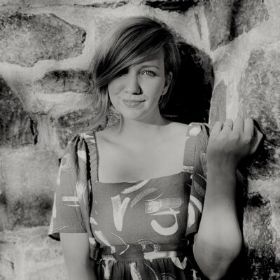 Black and white photograph of a woman with short hair wearing a dress.