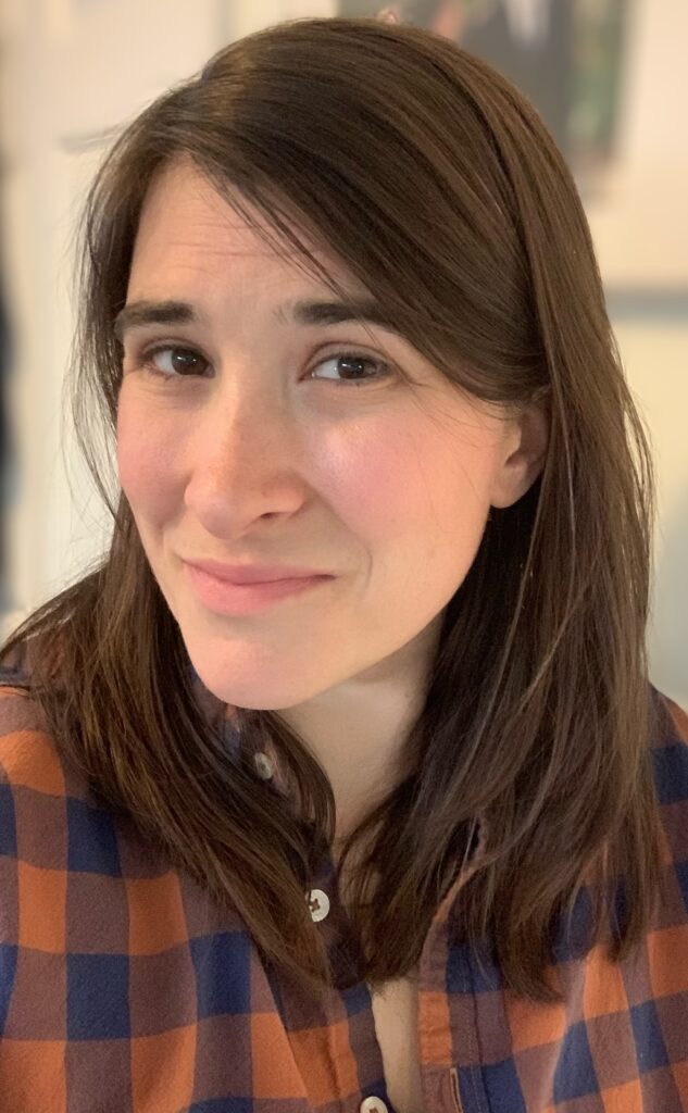 A photograph of Claire Taylor, a white woman with brown hair doing her best to look author-ly